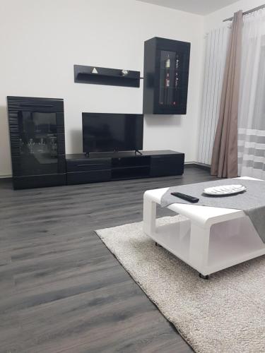 uma sala de estar com um sofá branco e uma televisão em Arrami Aparthotel em Satu Mare