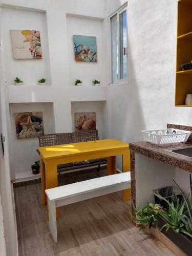 a yellow table in a room with a fireplace at Casa Esencia in Cozumel