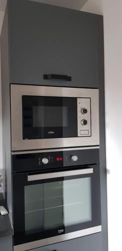 - un four noir et argent dans la cuisine dans l'établissement Le Chasnot, proche gare et centre ville, à Besançon