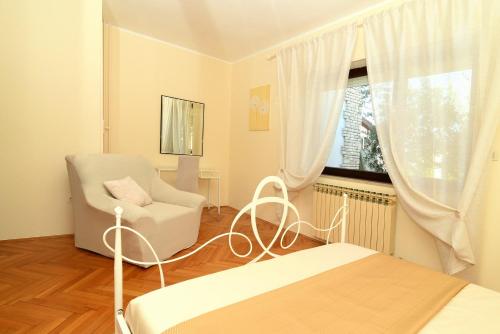Pokój z łóżkiem, krzesłem i oknem w obiekcie Holiday Home Villa Margherita w Puli
