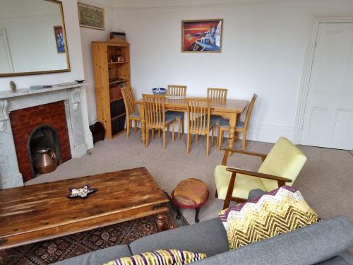 uma sala de estar com lareira e uma mesa e cadeiras em Bright, character 3 bed Apartment: 7 mins walk to sea em Portsmouth