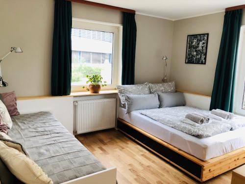 a bedroom with a bed and a window at urbanAPARTMENT No.1 Memmingen in Memmingen