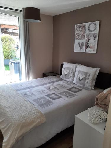 Un dormitorio con una cama grande y una ventana en Jac-Cosy, en Fleurier