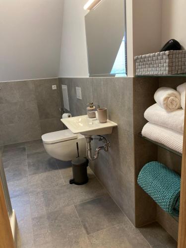 a bathroom with a sink and a mirror and towels at Schöne drei Raumwohnung. Hell,stilvoll, gemütlich. in Borna