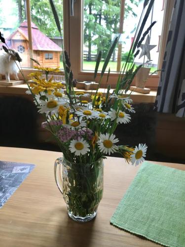a glass vase filled with flowers on a table at Chalet Karin in Hochfilzen