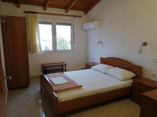 Un dormitorio con una cama grande y una ventana en Irini Apartments, en Keramotí