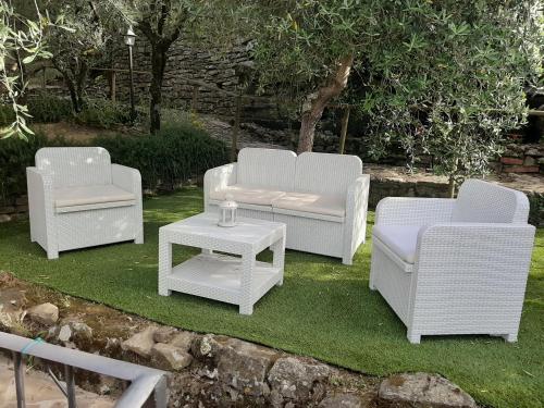 a group of white chairs and a table on grass at Casa Vacanze Ada in Fiesole