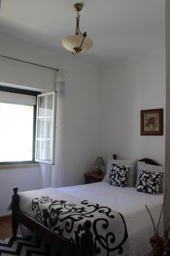 a bedroom with a bed and a window at Two bedroom apartment, two minutes from the beach in Nazaré
