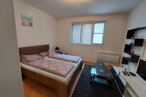 een slaapkamer met een bed en een tafel. bij Apartment Đozić in Srebrenica