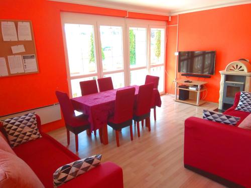 a living room with a red dining room table and chairs at Koppi Ház in Siófok