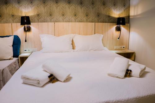 a bedroom with a white bed with two towels on it at Loutraki hidden Gem II in Loutraki
