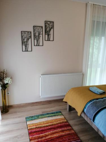 sypialnia z czterema zdjęciami wiszącymi na ścianie w obiekcie Boglárka Apartman w Segedynie