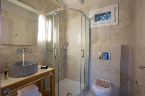 a bathroom with a shower and a sink and a toilet at Evridiki's Villas in Agios Nikitas