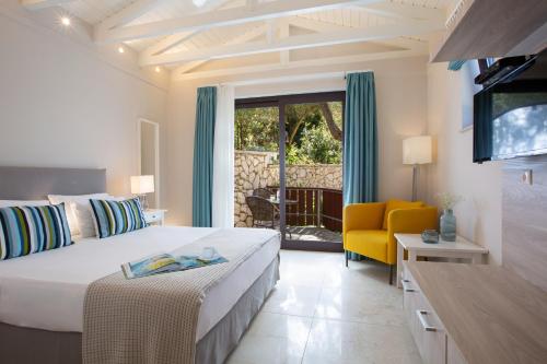 a bedroom with a bed and a yellow chair at Evridiki's Villas in Agios Nikitas