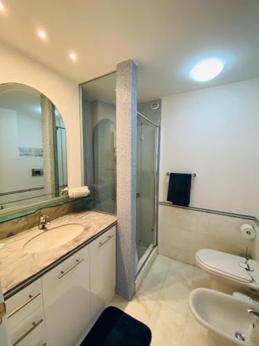 a bathroom with a sink and a toilet and a shower at Super attico sul mare in Lido di Camaiore