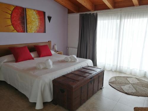 a bedroom with a large bed with red pillows at Cal Roig Hotel Rural in Vilafranca del Penedès