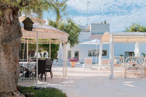 eine Terrasse mit Pavillon und Tischen und Stühlen in der Unterkunft B&B Antico Ulivo in Monopoli