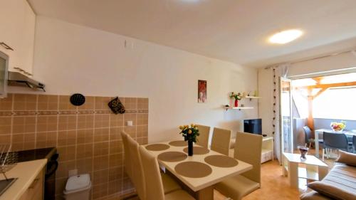 Apartments Dario في ميدولين: مطبخ وغرفة معيشة مع طاولة وكراسي