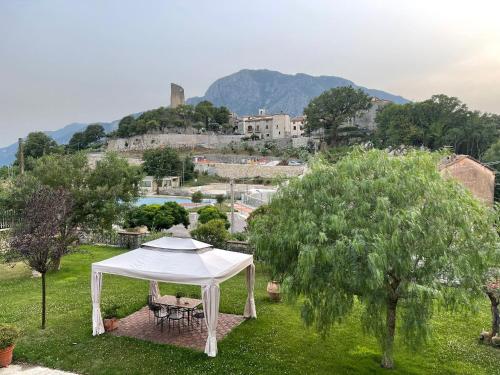 a white gazebo in a field with a castle in the background at Villa Palmina in Castelnuovo Parano