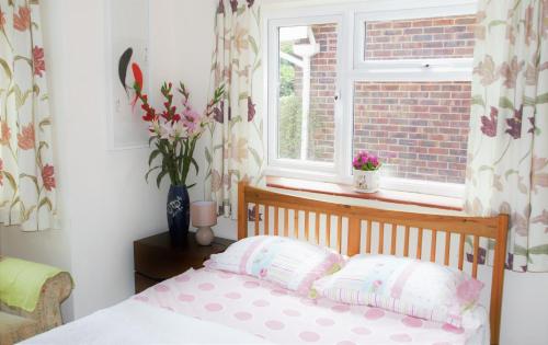 a bedroom with a bed in front of a window at The Witterings Bed and Breakfast in Chichester