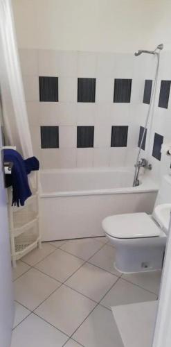 a bathroom with a white tub and a toilet at Rêve bleu in Le Gosier