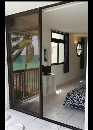 a room with a sliding glass door with a view of the ocean at Rêve bleu in Le Gosier