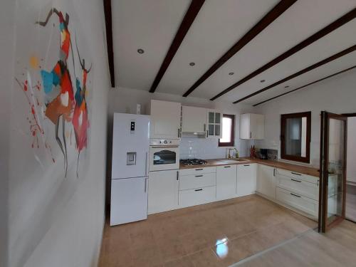 una cocina con electrodomésticos blancos en una habitación en House for rent en Zubovići