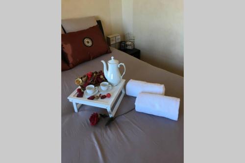 a bed with a table with a tea pot on it at Le Domaine du Château in Seynod