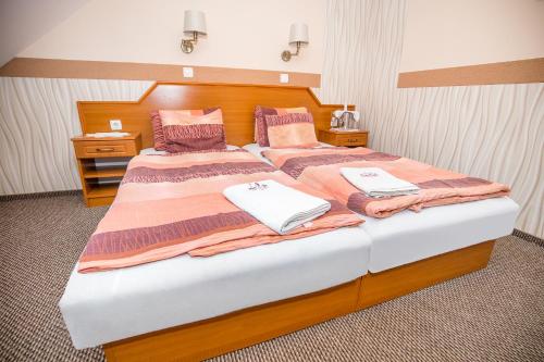 a bedroom with two beds with towels on them at Tinódi Fogadó in Sárvár