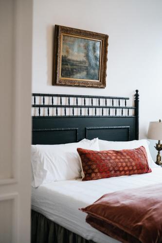 a bed with a black headboard and a picture on the wall at The Inn in Buena Vista