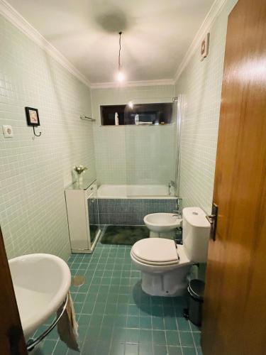 a bathroom with two sinks and a toilet and a tub at Casa do Tapadinho in Ribeira de Pena
