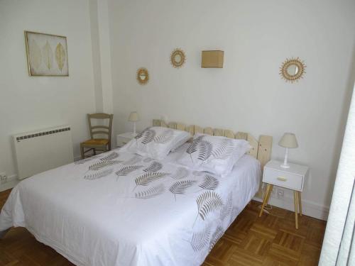 - une chambre dotée d'un lit blanc avec des draps et des oreillers blancs dans l'établissement L'Agapanthe 3 étoiles Joli appartement en bord de mer, à Dieppe