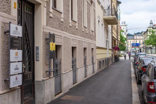 une rue avec des voitures garées sur le côté d'un bâtiment dans l'établissement Loni's Place Apartments, à Ljubljana