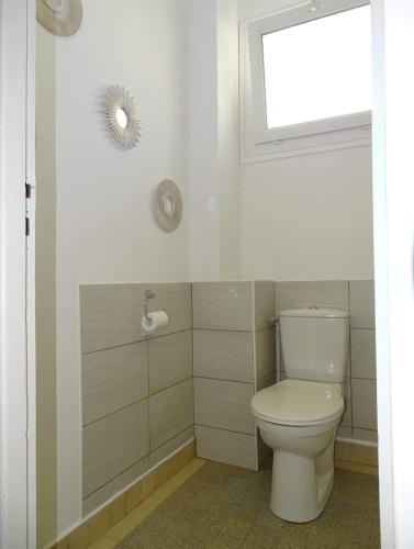 une salle de bain avec des toilettes blanches et une fenêtre dans l'établissement L'Agapanthe 3 étoiles Joli appartement en bord de mer, à Dieppe