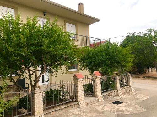 a house with a fence and trees in front of it at Apartment Mate in Pridraga