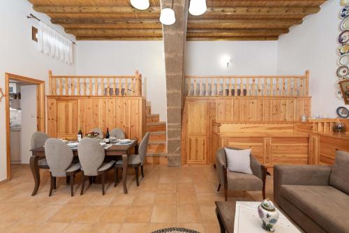 a dining room with a table and chairs and a couch at Traditional House Leventis in Archangelos