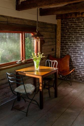 a wooden table with a vase of flowers on a porch at Laawu Kultaa in Kotka