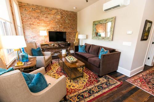 a living room with a couch and a brick wall at The Windsor - Asheville in Asheville