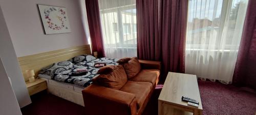 um quarto com uma cama, um sofá e uma mesa em Brasna Apartment 1 - Kupalisko em Nové Zámky