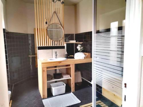 uma casa de banho com um lavatório e um espelho em La Dolce Vita Lucie em Vals-les-Bains
