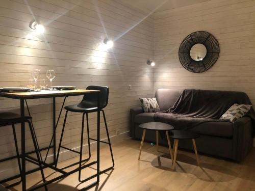 - un salon avec un canapé et une table avec des tabourets dans l'établissement Le clos Saint Patern, à Vannes