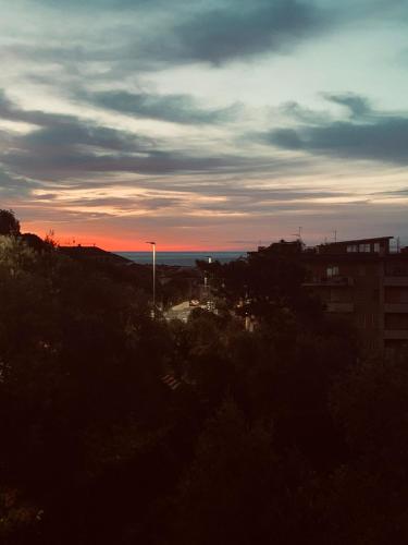 a sunset over a city with the ocean in the background at TERRAZZA SUL MARE IN VIA DEVOTO in Chiavari