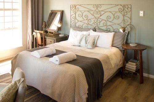 a bedroom with a large bed with two pillows at Dreamy Beach Room in Melkbosstrand