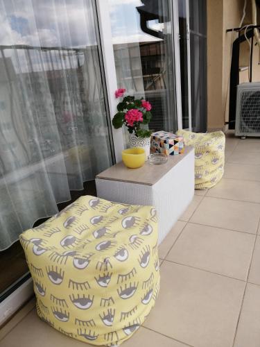 two stools and a table with flowers on a balcony at Art House in Floreşti