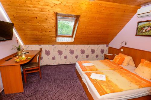 a hotel room with a bed and a desk and a computer at Tinódi Fogadó in Sárvár