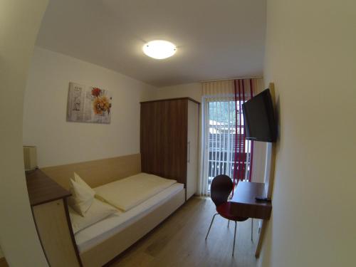 a small room with a bed and a window at Pension Wörndl in Fuschl am See