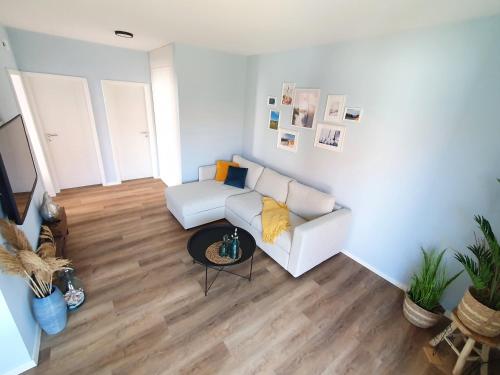 un soggiorno con un divano bianco e un tavolo di Fewo Lieblingsort Norddeich a Norddeich