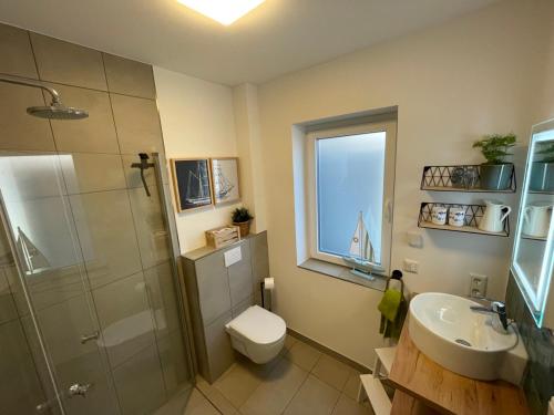 un bagno con doccia, WC e lavandino di Fewo Lieblingsort Norddeich a Norddeich