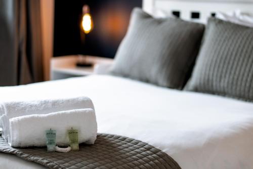 a bed with two towels and a basket on it at 4 bed family home wifi, netflix, parking, close to wicksteed park in Kettering
