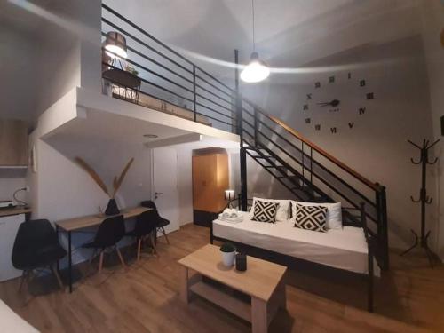 a room with a bed and a staircase with chairs at Speri's Loft in Preveza